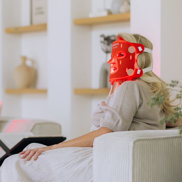 Vrouw op de bank met het Liroma LED masker voor het gezicht